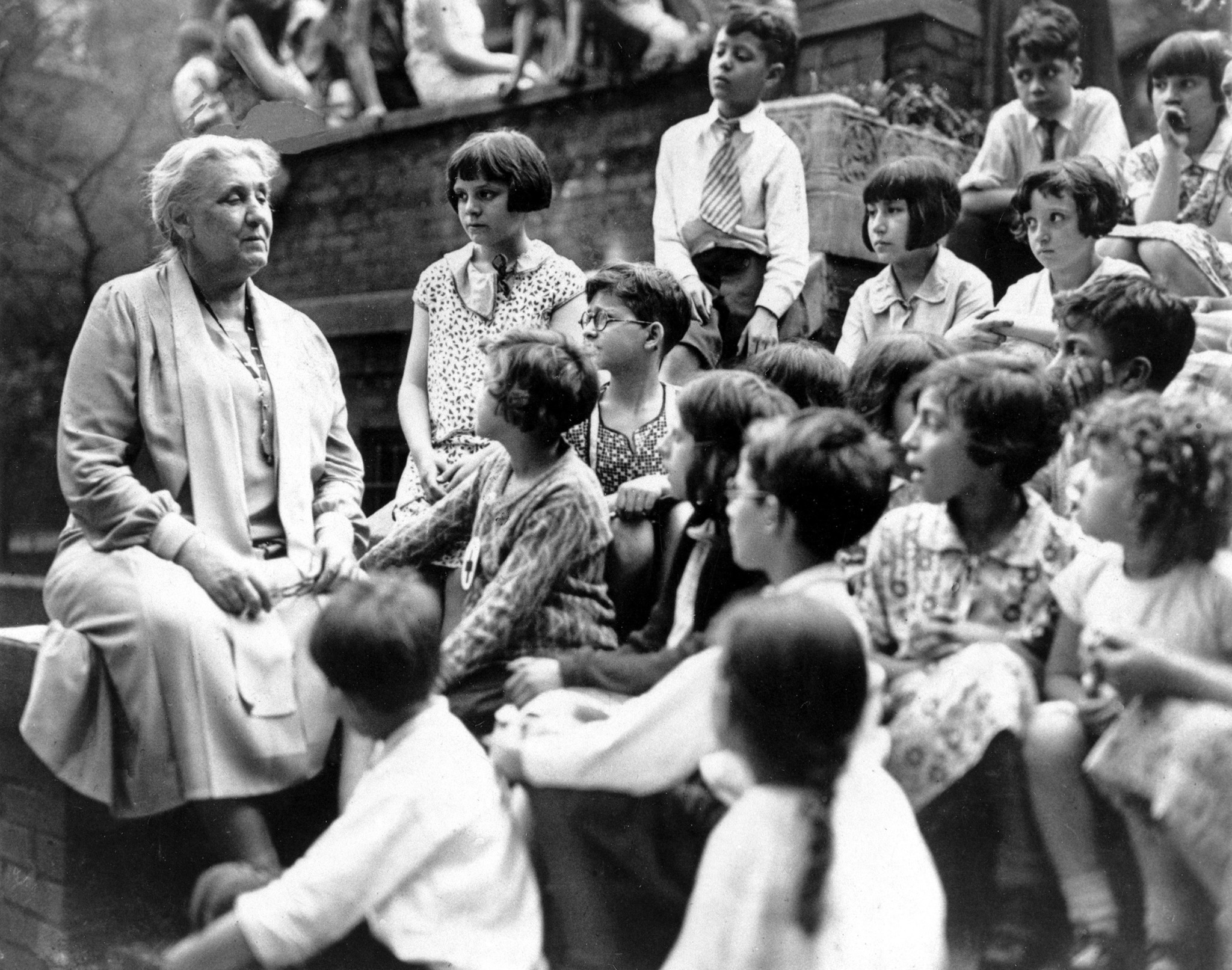 Social work pioneer Jane Addams talks with young people visiting...