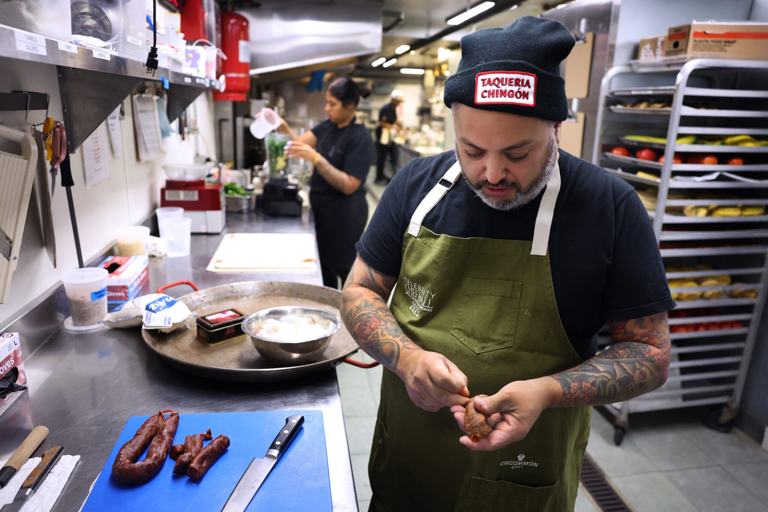 Chef Marcos Asencio works with chorizo to be used in...