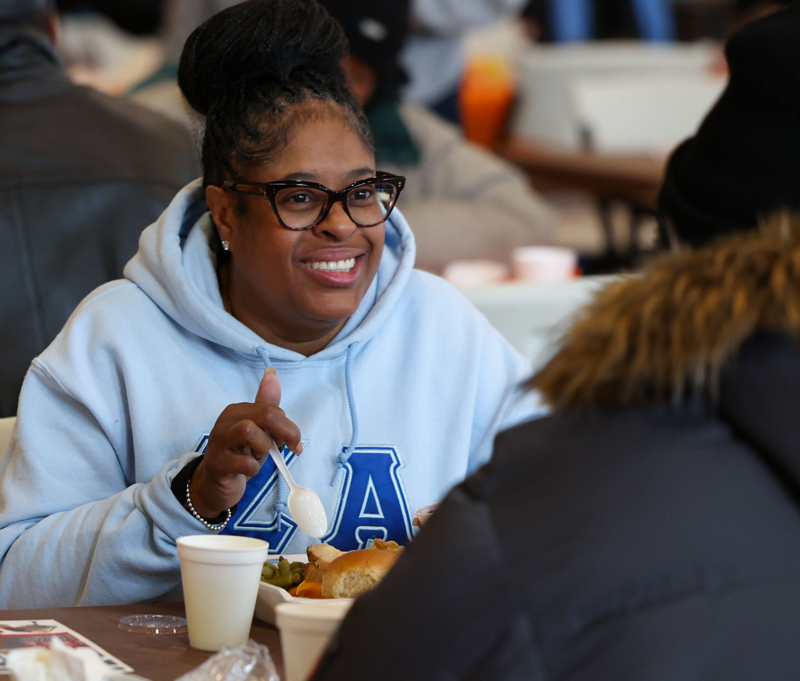 Volunteer Belina D. Lambert eats a Thanksgiving dinner with a...