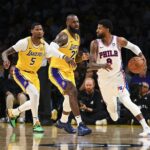 Nov 8, 2024; Los Angeles, California, USA; Philadelphia 76ers forward Paul George (8) looks to pass against Los Angeles Lakers forward LeBron James (23) and forward Cam Reddish (5) during the second half at Crypto.com Arena. Mandatory Credit: Jonathan Hui-Imagn Images