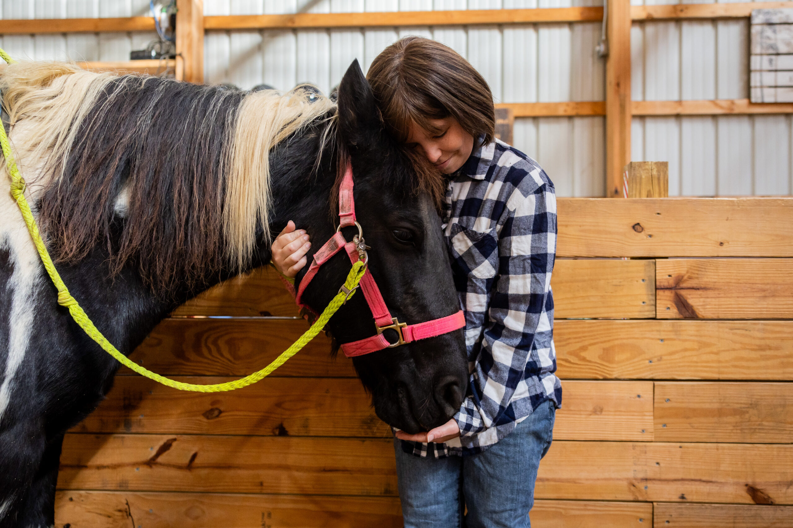 Sarah Sauer, 31, hugs a horse in between assisting her...