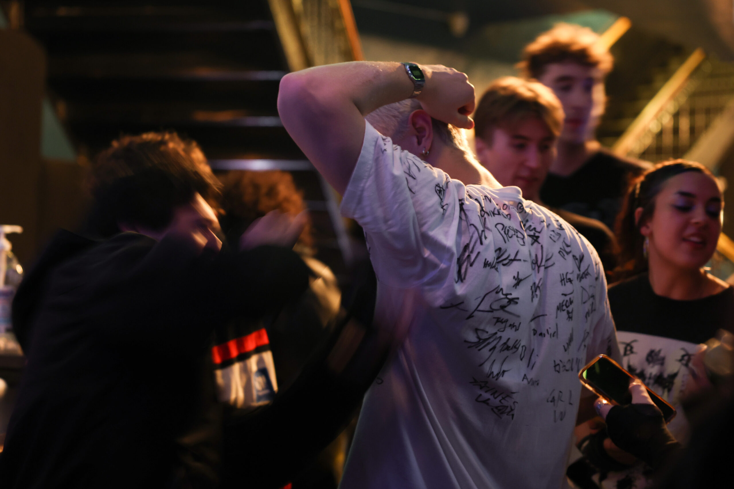 A concertgoer has people sign his T-shirt before 2hollis takes...